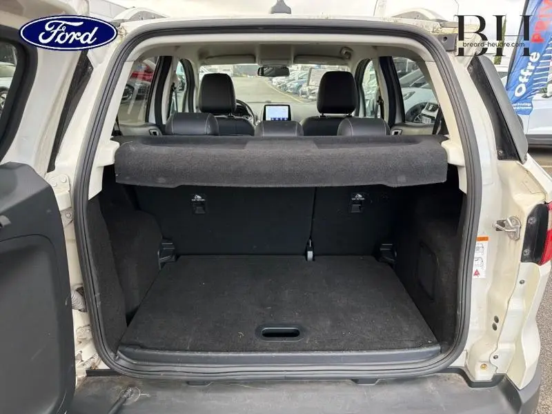 Vue arrière du coffre ouvert d'un Ford EcoSport blanc Fashion Blanc Metropolis avec banquette arrière et tablette cache-bagages visibles.