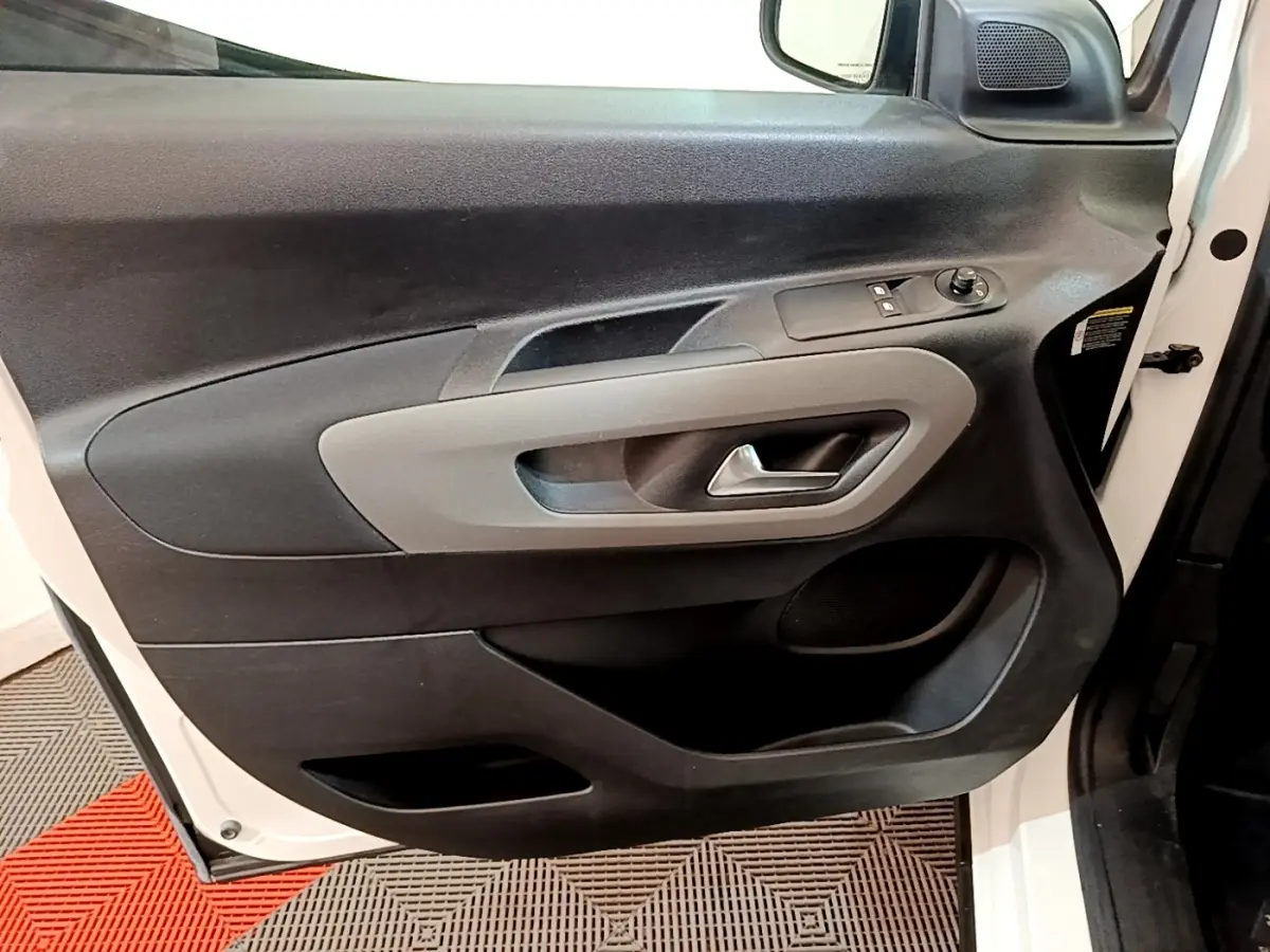 Vue rapprochée de la porte avant gauche blanche du Peugeot Rifter 2019, avec commandes électriques et poignée grise.