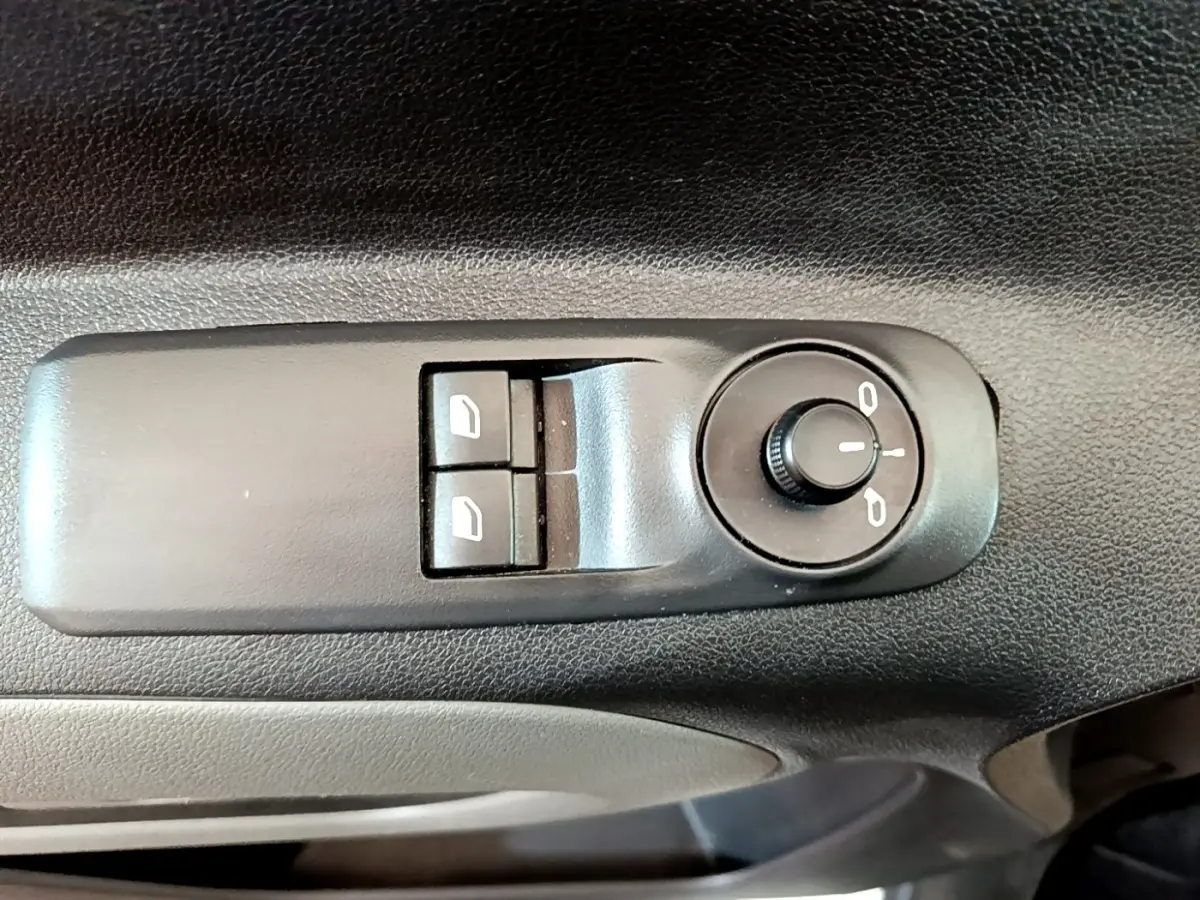 Gros plan sur les commandes de réglage des rétroviseurs et des vitres électriques côté conducteur du Peugeot Rifter blanc.