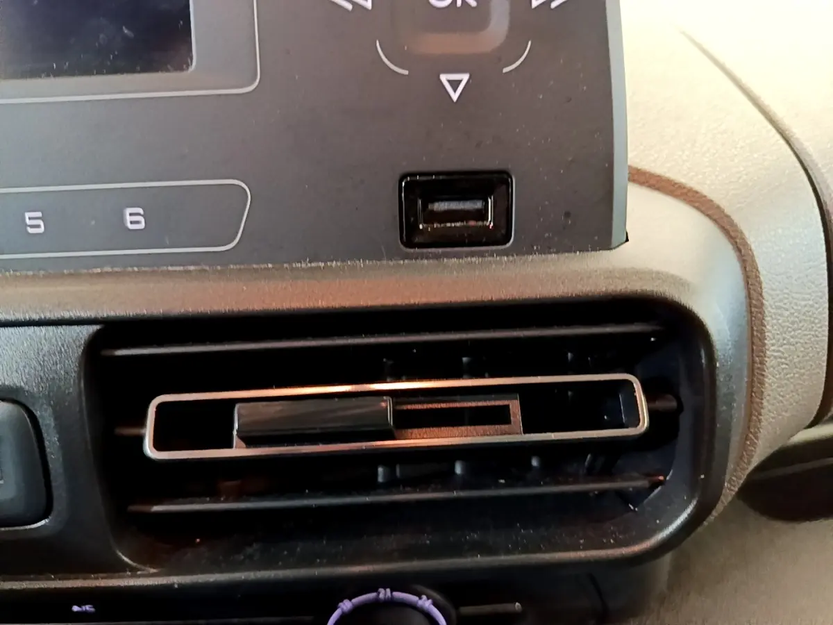 Gros plan sur la sortie d’air centrale du tableau de bord du Peugeot Rifter blanc, version PureTech 110 S&S Active.