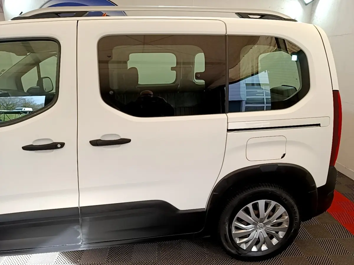 Vue latérale droite d'un Peugeot Rifter blanc de 2019 avec portes coulissantes et jantes alliage.