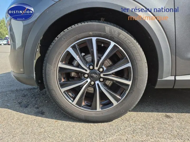 Gros plan sur la jante alu noire et argent du côté avant gauche du Ford Puma gris métallisé 2022.