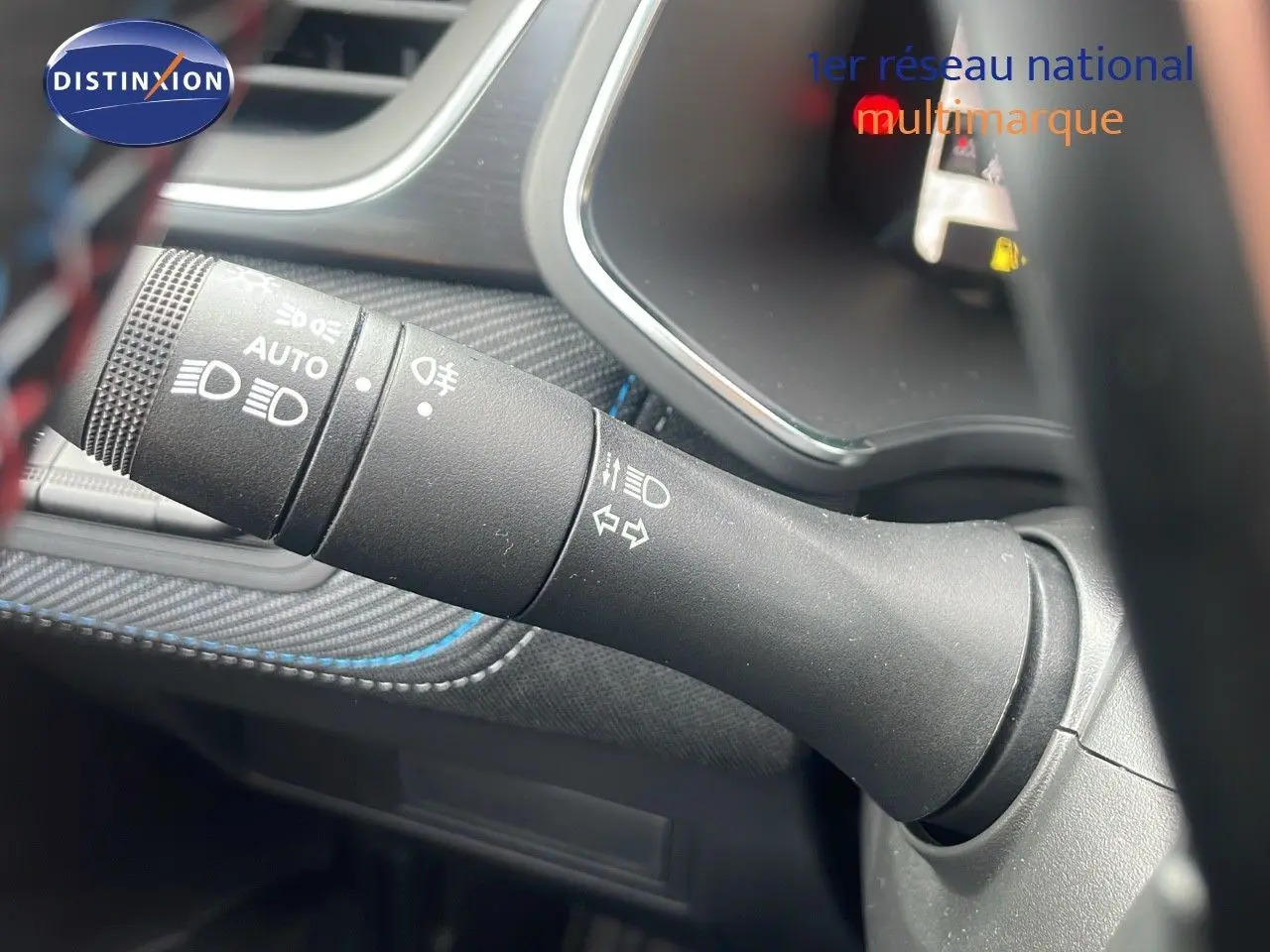 Gros plan sur la commande des feux et clignotants dans l'habitacle du Renault Captur E-Tech hybride gris cassiopée.