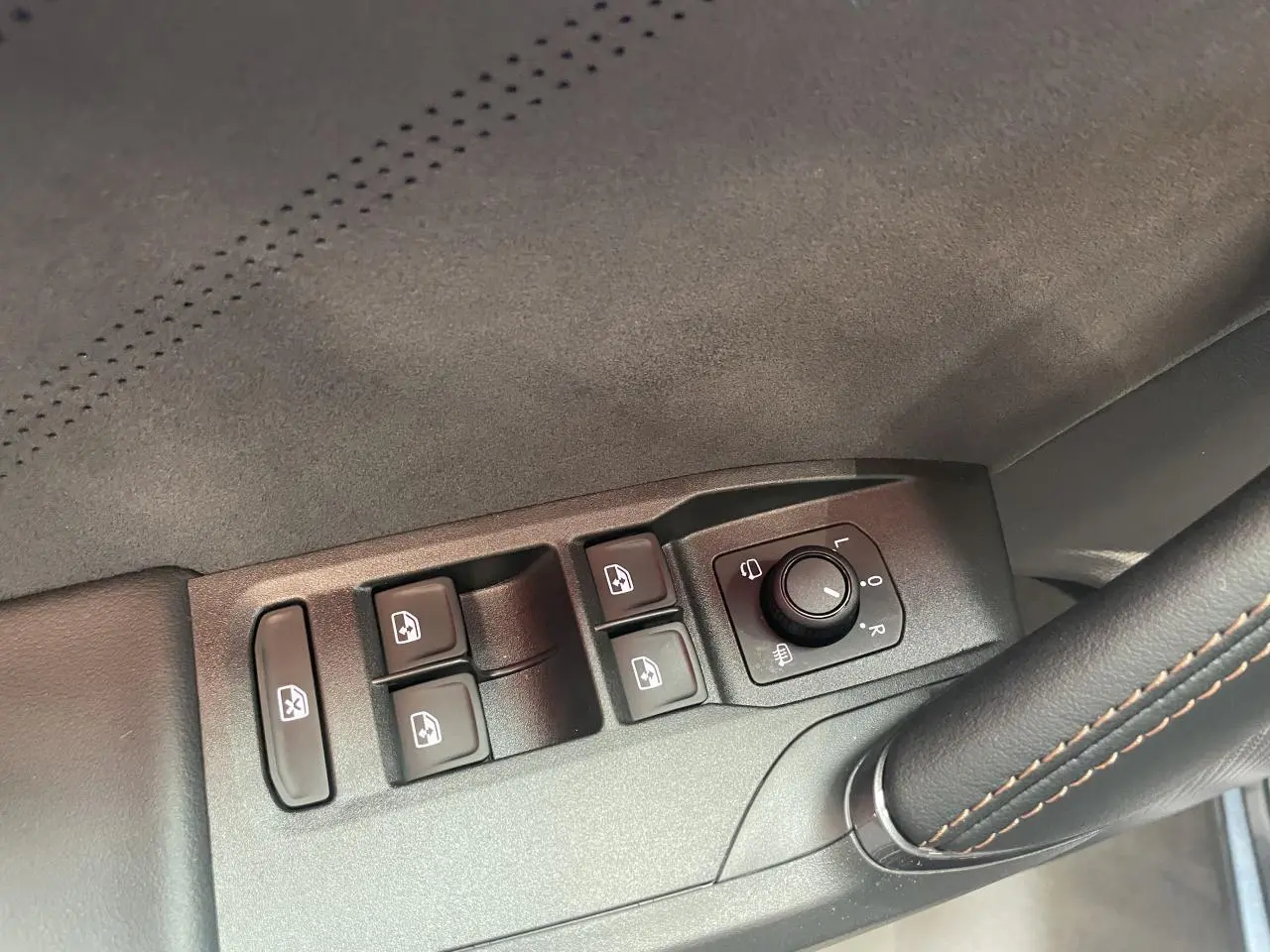 Détail des commandes de lève-vitres et réglage des rétroviseurs sur la porte côté conducteur d’une CUPRA Leon gris Magnetic.