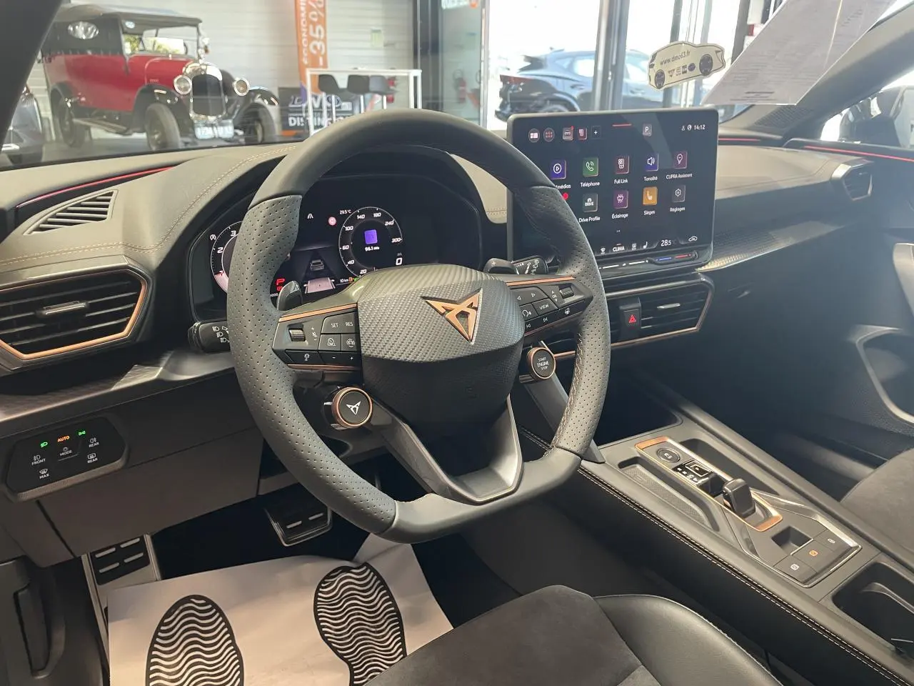 Vue intérieure du poste de conduite de la CUPRA Leon 2026, volant cuir perforé avec logo cuivré et écran tactile HD.