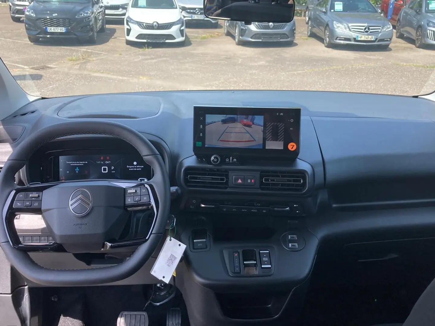 Vue intérieure avant du tableau de bord noir du Citroën Berlingo 2026 avec écran tactile affichant la caméra de recul.