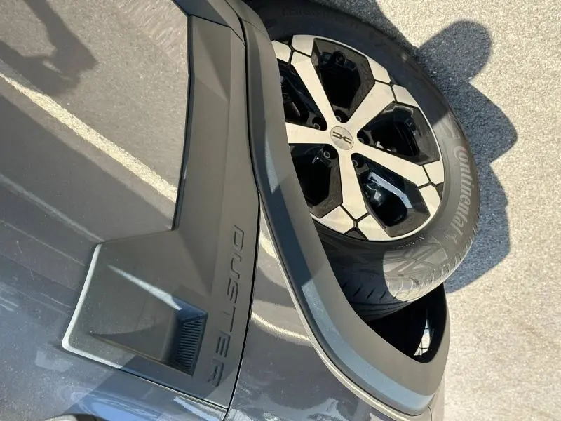 Gros plan sur la roue arrière droite et l’arche de roue noire du Dacia Duster blanc Glacier 2025.