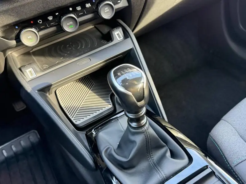 Gros plan sur la console centrale de la Citroën C4 2024 gris, montrant le levier de vitesse manuel et les commandes de climatisation.