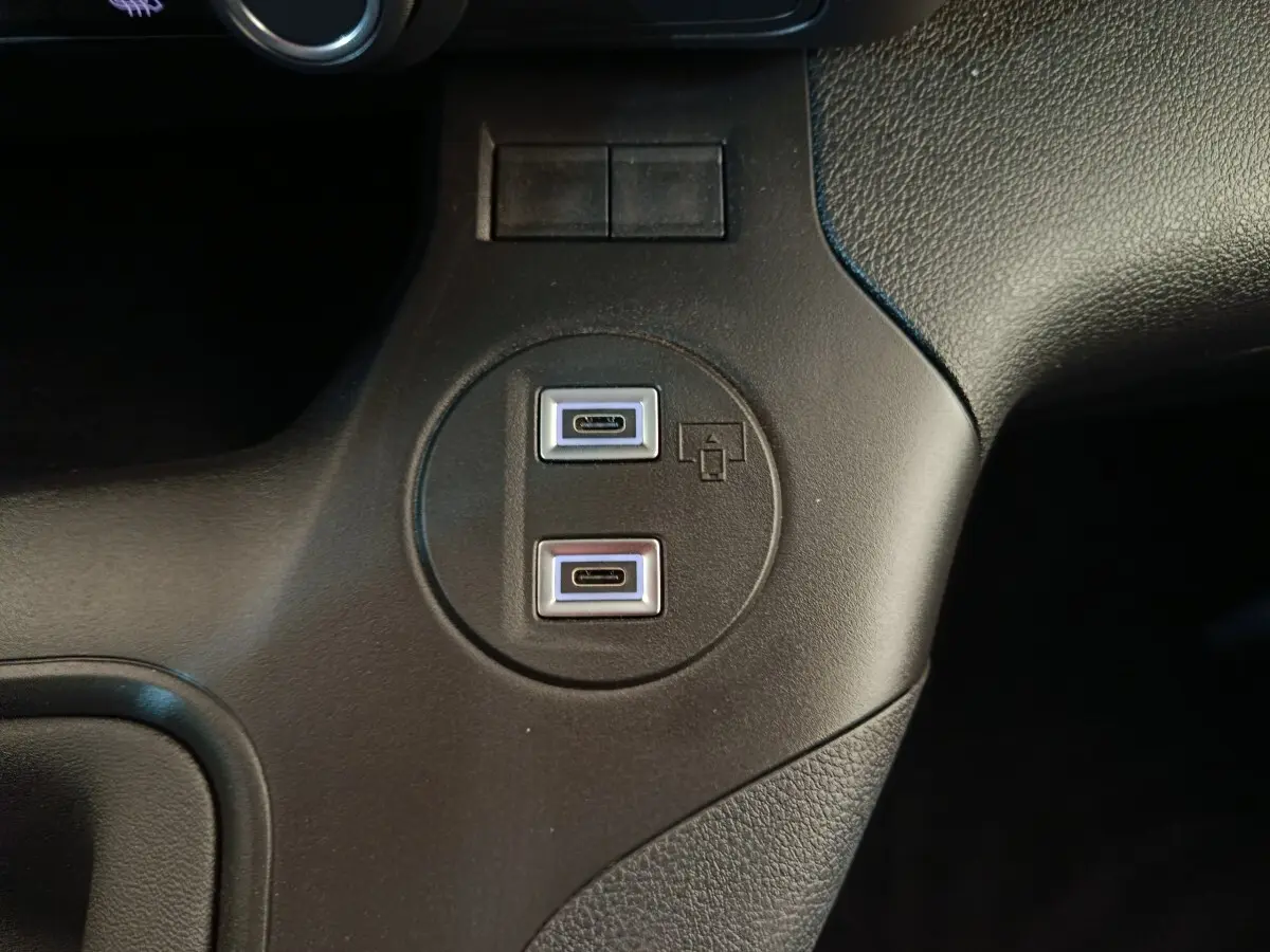 Vue rapprochée des deux ports USB-C intégrés dans la console centrale noire du Peugeot Partner blanc 2026.