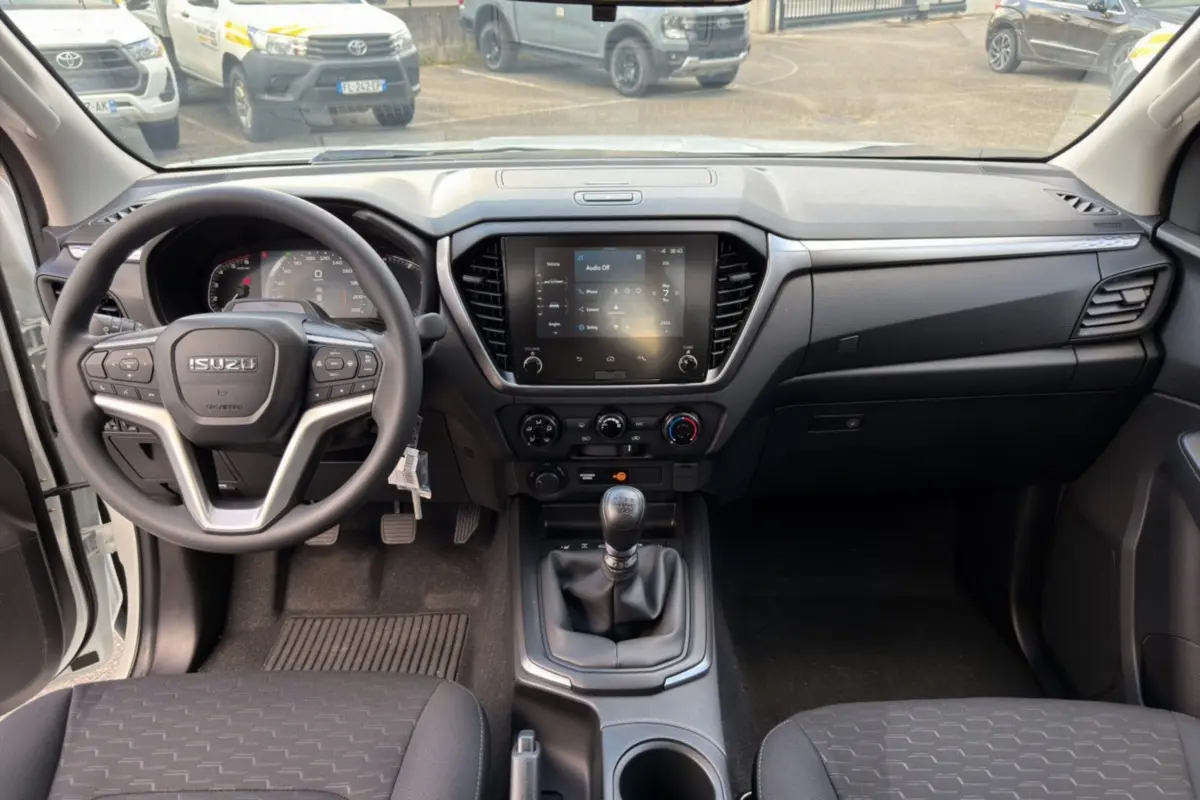 Vue intérieure avant de l'Isuzu D-MAX 2.2 TD 164 Space Evolution avec tableau de bord et boîte manuelle visible.