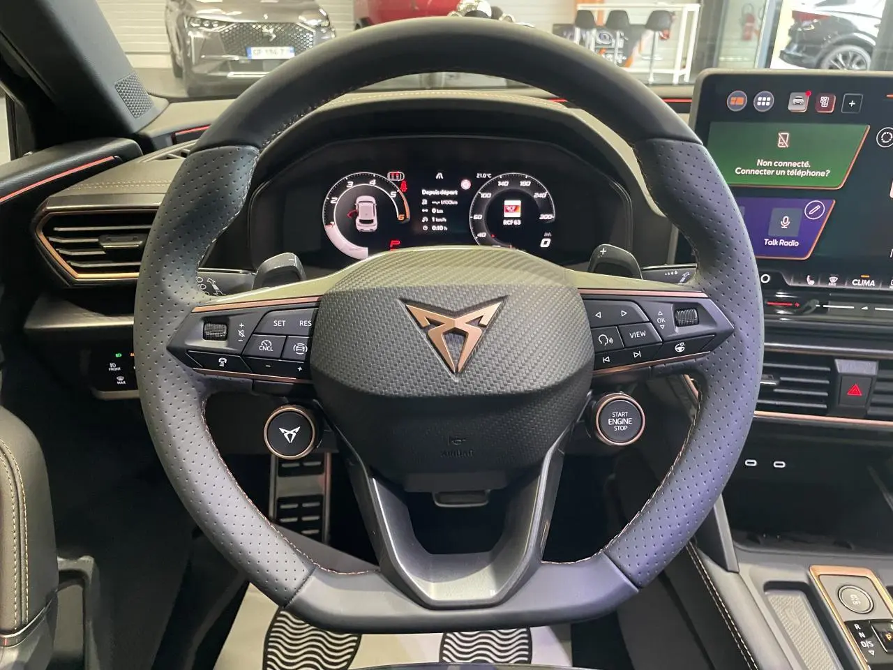 Vue rapprochée du volant noir perforé avec logo CUPRA cuivré et tableau de bord digital d'une CUPRA Leon 2026.