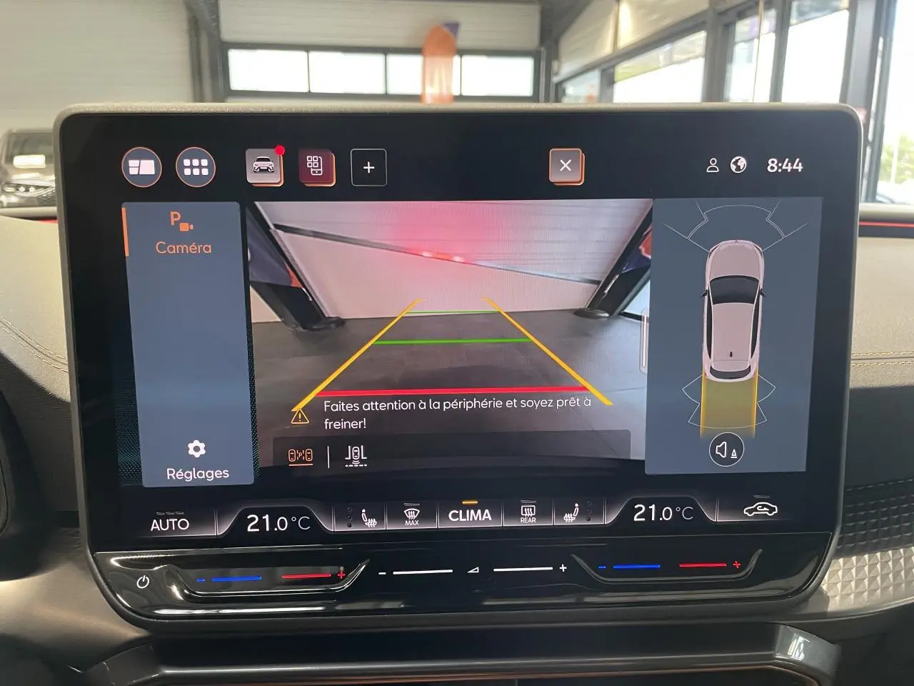 Écran tactile intérieur affichant la caméra de recul et l’aide au stationnement du CUPRA Leon noir, vue frontale du tableau de bord.