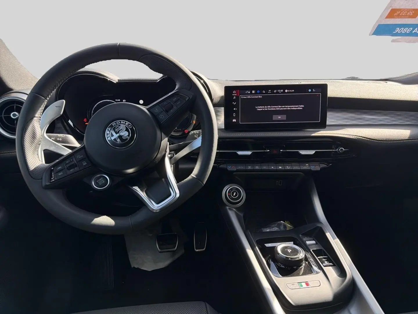 Vue intérieure du poste de conduite de l'Alfa Romeo Tonale 2025, volant cuir sport et écran tactile central visible.