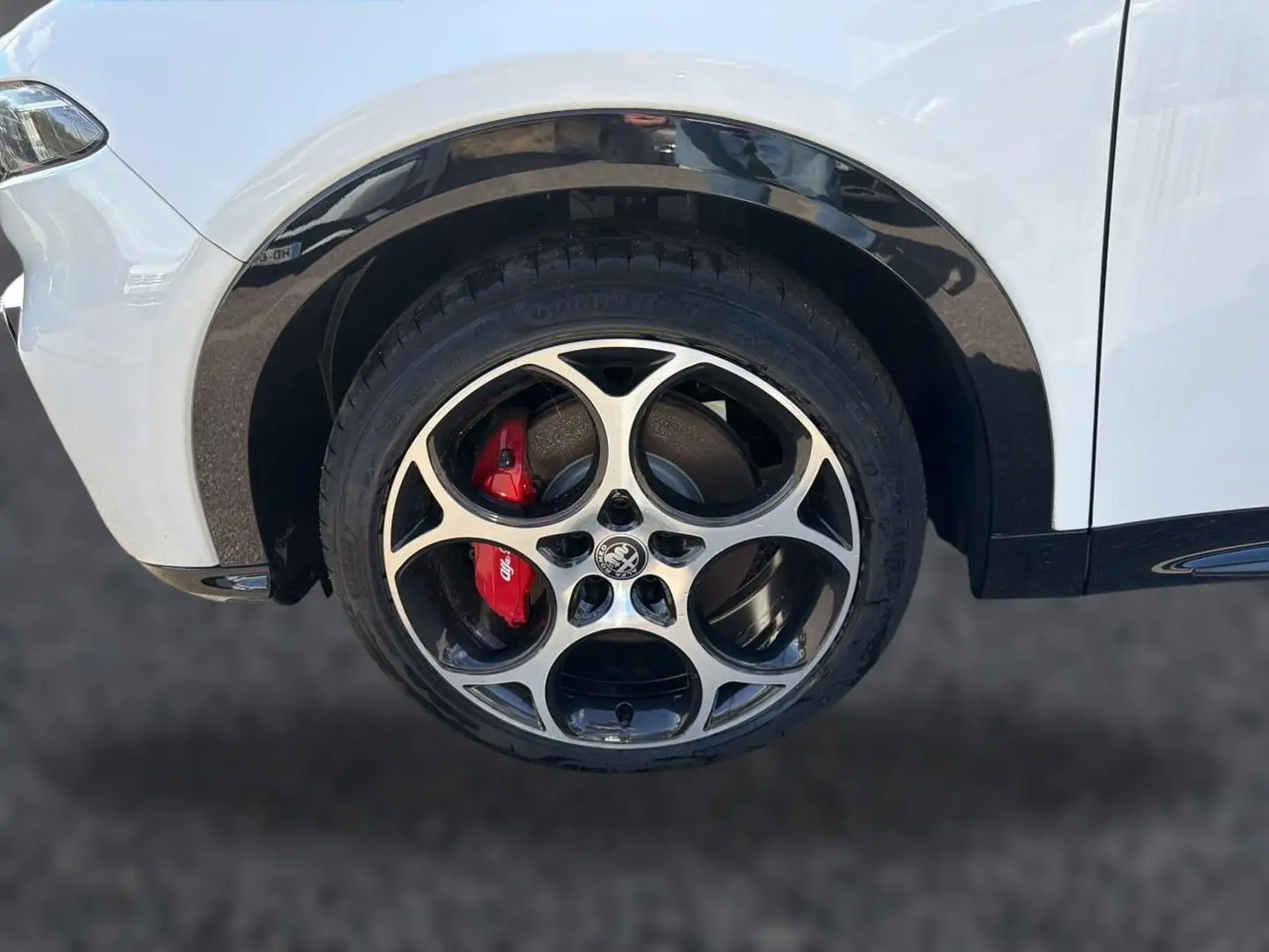 Gros plan sur la roue avant gauche blanche d'Alfa Romeo Tonale 2025 avec étrier de frein rouge et jante alu distinctive.
