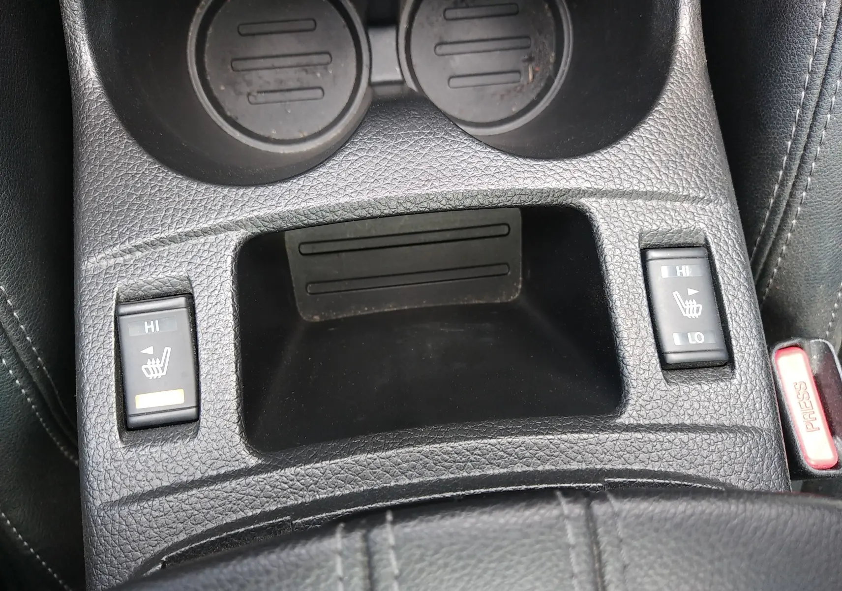 Gros plan sur la console centrale en cuir noir du Nissan Qashqai 2018, montrant les commandes de sièges chauffants.