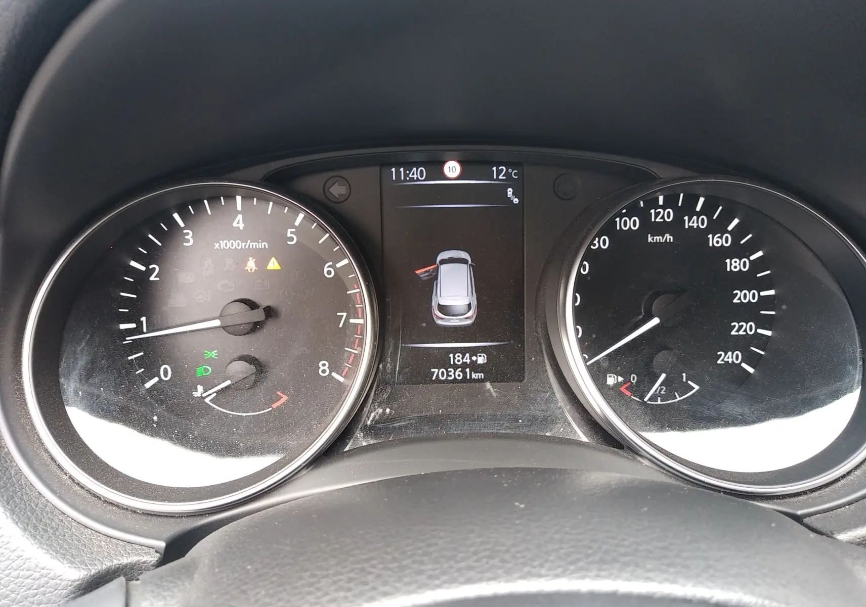 Vue rapprochée du tableau de bord du Nissan Qashqai blanc 2018, affichant compte-tours, vitesse et écran central.