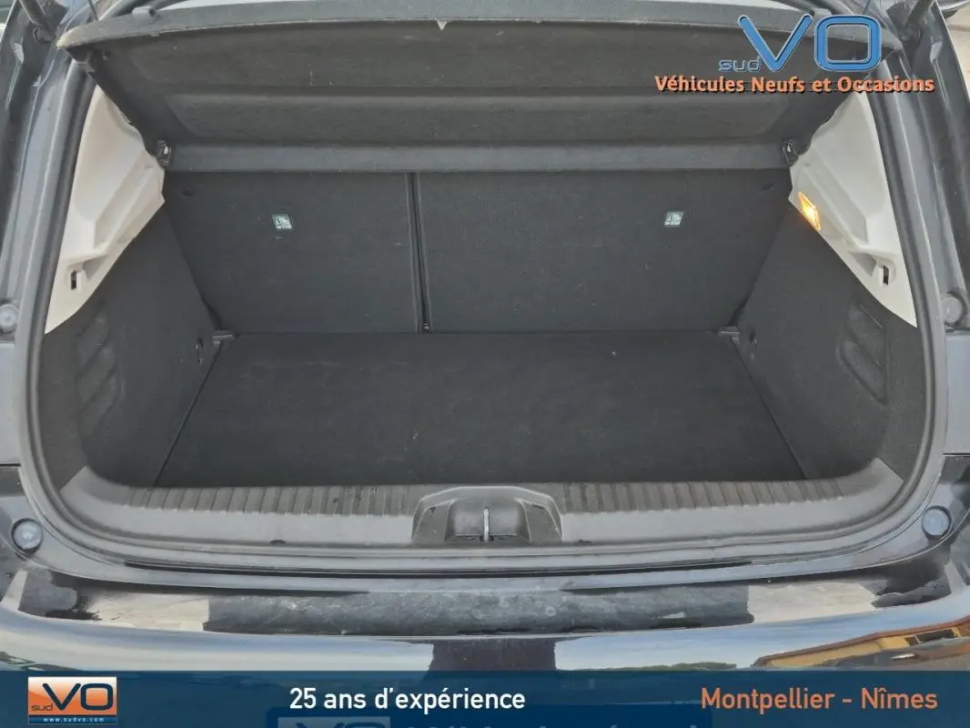 Coffre ouvert d'une Renault Clio V TCe 90 Equilibre noire de 2023, montrant un espace de chargement propre et spacieux.