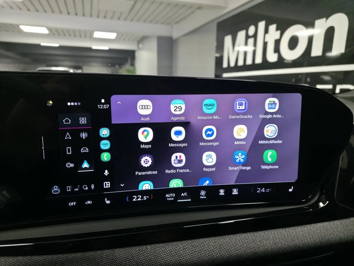 Écran tactile MMI central allumé dans l'habitacle de l'Audi A5 Avant noir, affichant plusieurs applications.