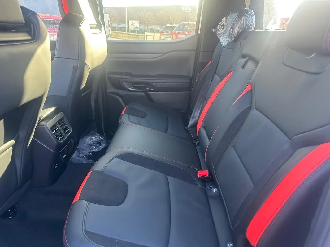 Vue intérieure côté droit des sièges arrière noirs avec surpiqûres rouges du Ford Ranger Double Cabine 2025.