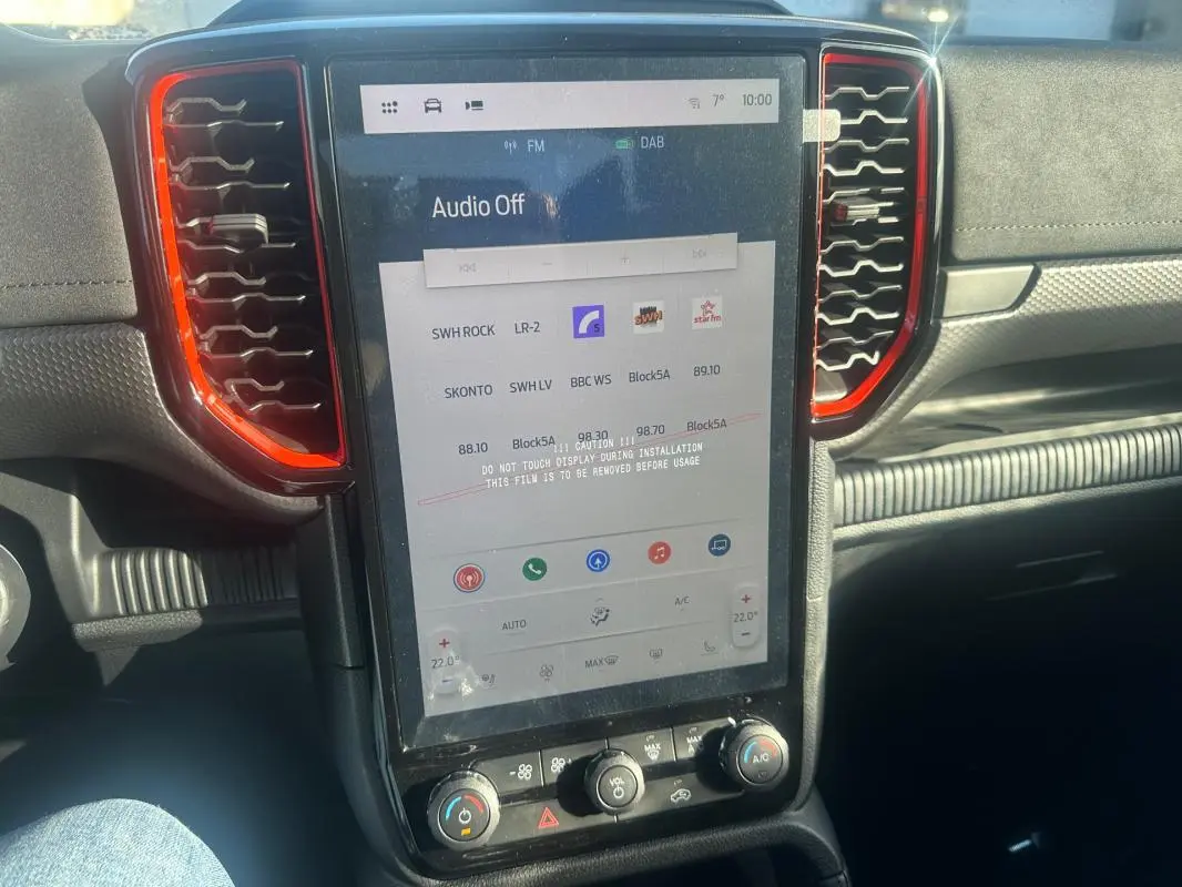 Vue rapprochée de l’écran tactile central du Ford Ranger Raptor 2025 avec entourage d’aération rouge et tableau de bord noir.