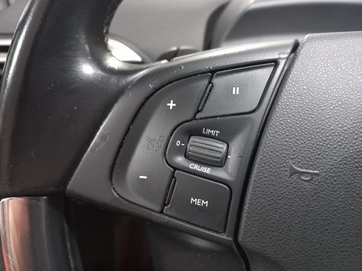 Gros plan sur les commandes de régulateur de vitesse au volant cuir noir du Citroën Grand C4 Spacetourer 2018.