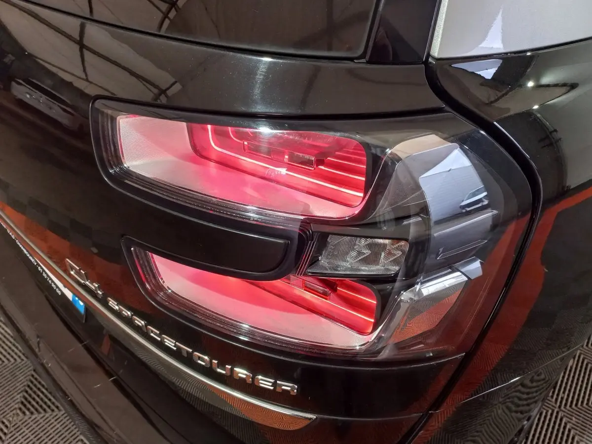 Gros plan sur le feu arrière droit rouge du Citroën Grand C4 SpaceTourer noir, avec logo visible sur le hayon.