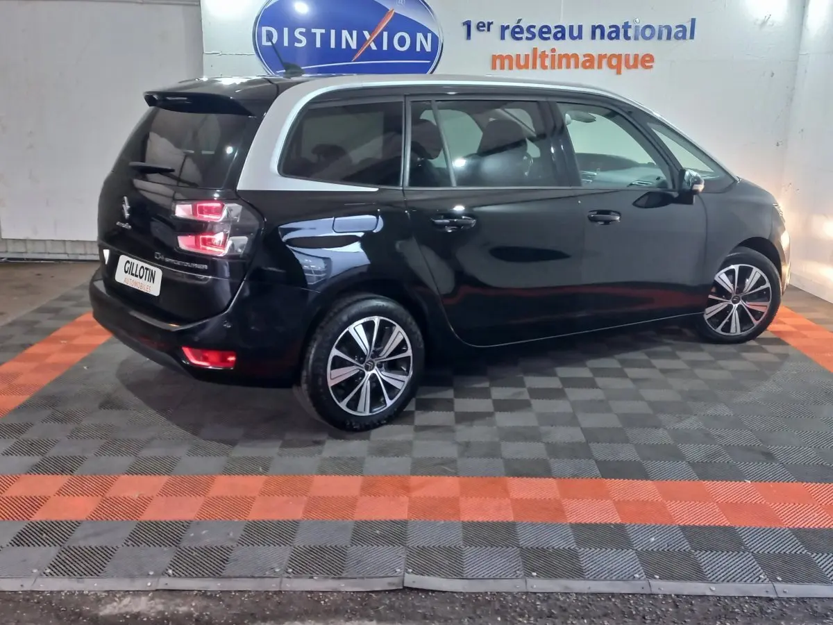 Vue 3/4 arrière gauche d'un Citroën Grand C4 Spacetourer noir avec toit contrastant blanc et jantes alliage.