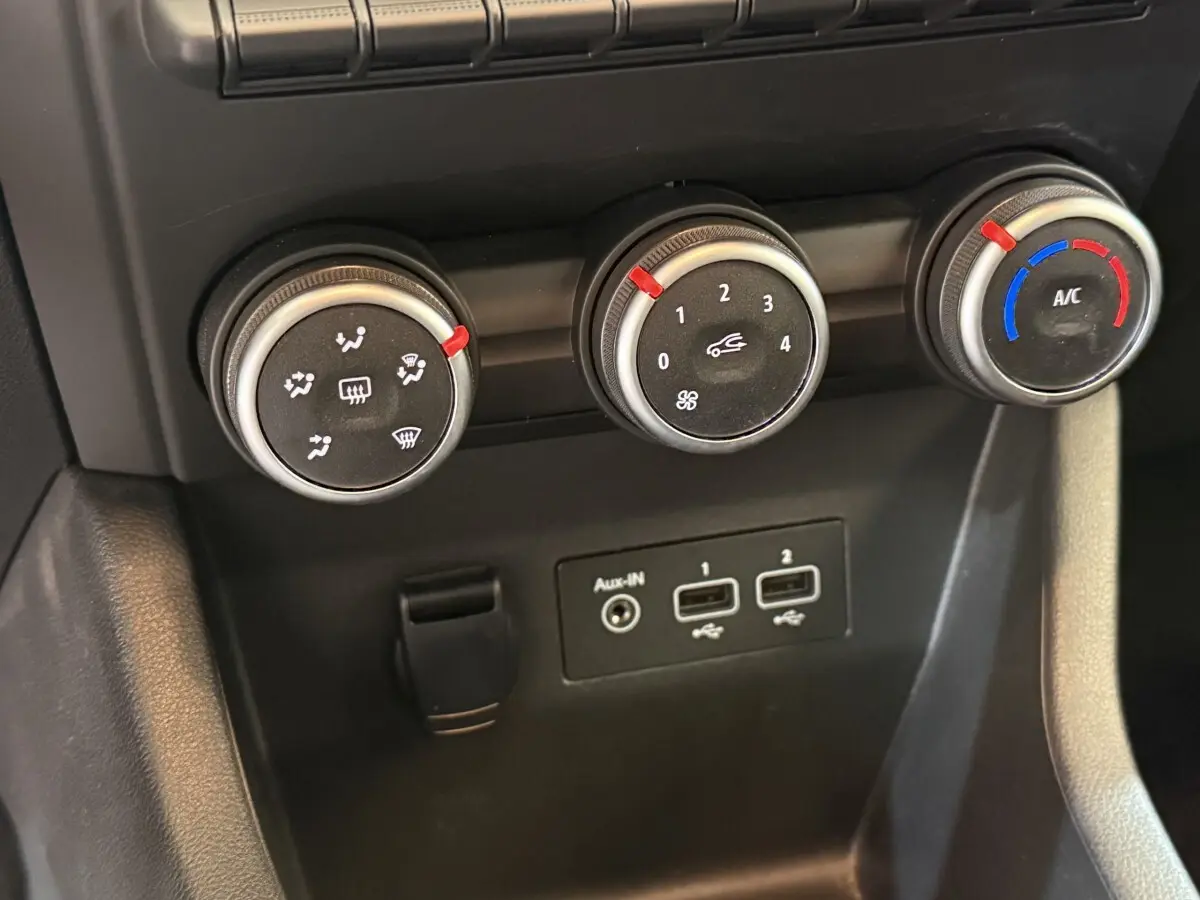 Gros plan sur les commandes de climatisation et les ports USB de la Renault Clio Business TCe 100 GPL blanche.