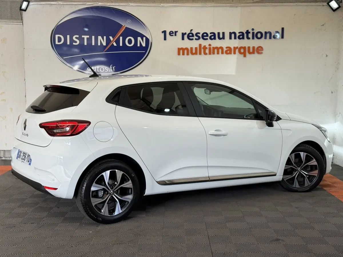 Profil droit d'une Renault Clio blanche 2022 Business TCe 100 GPL, avec jantes alliage et feux arrière LED visibles.