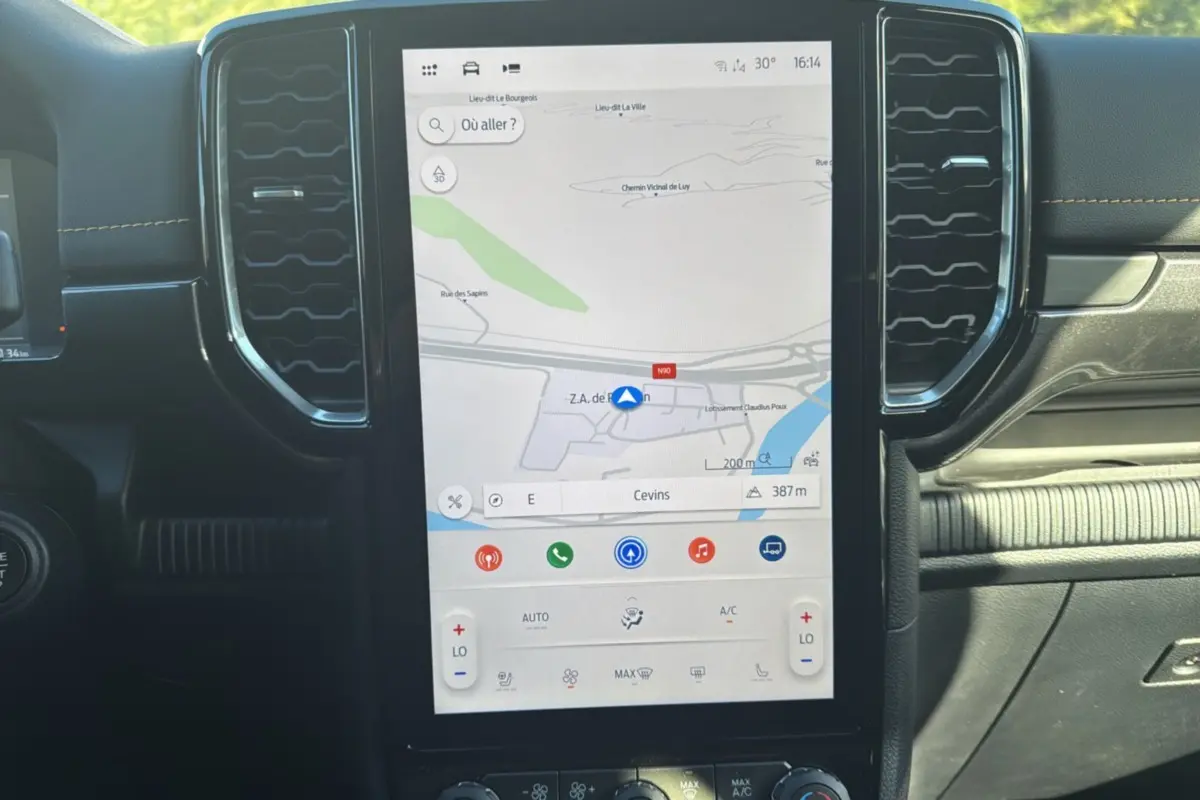 Vue rapprochée de l’écran tactile central du Ford Ranger gris carbone 2025 avec navigation et commandes climatisation.