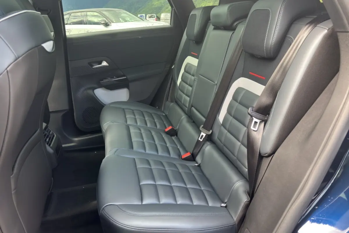 Vue intérieure côté droit sur la banquette arrière cuir noir matelassé du Citroën C5 Aircross New Hybrid 2026 bleu eclipse.