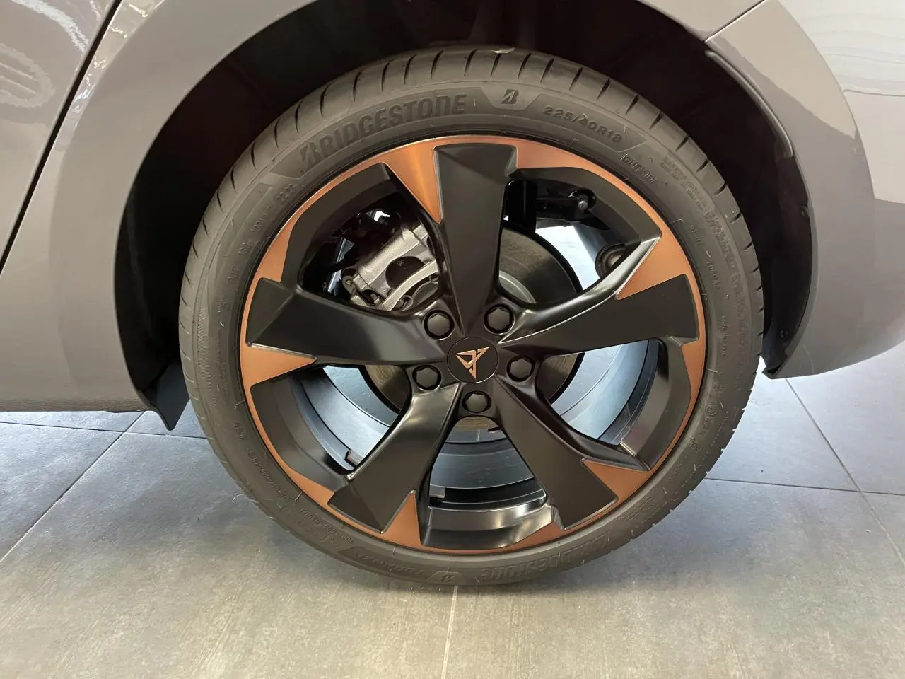 Gros plan sur la jante alliage 18'' cuivrée et noire du CUPRA Leon Gris Graphène, avec logo central distinctif.