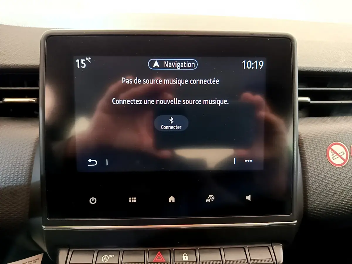 Écran tactile central du tableau de bord de la Renault Clio Business blanche, affichant le menu de connexion musicale.