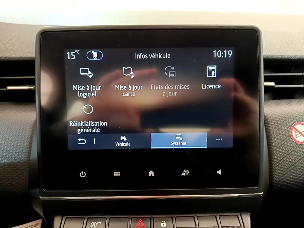 Écran tactile central du tableau de bord de la Renault Clio Business blanc, affichant les options de mise à jour système.