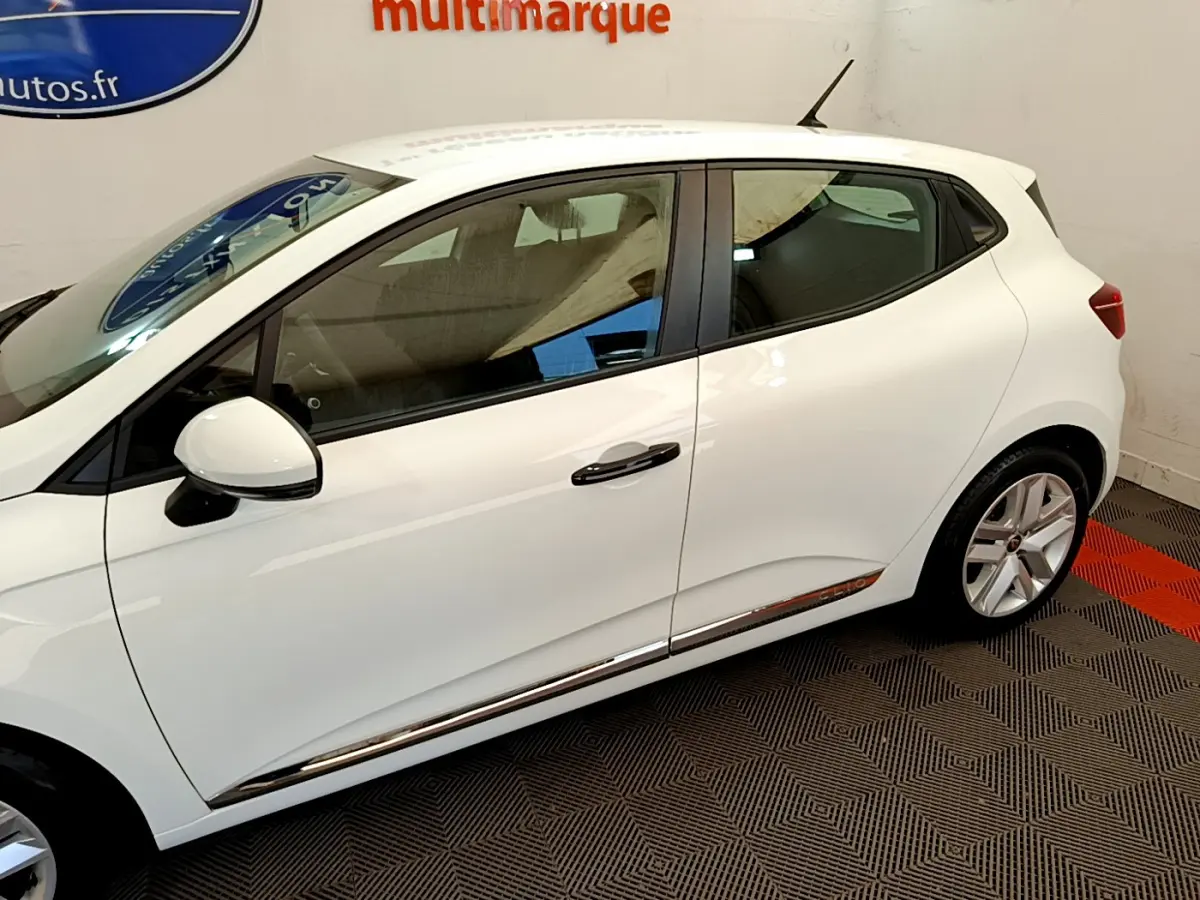 Profil droit de la Renault Clio Business blanche de 2021, avec poignées noires et jantes alliage visibles.