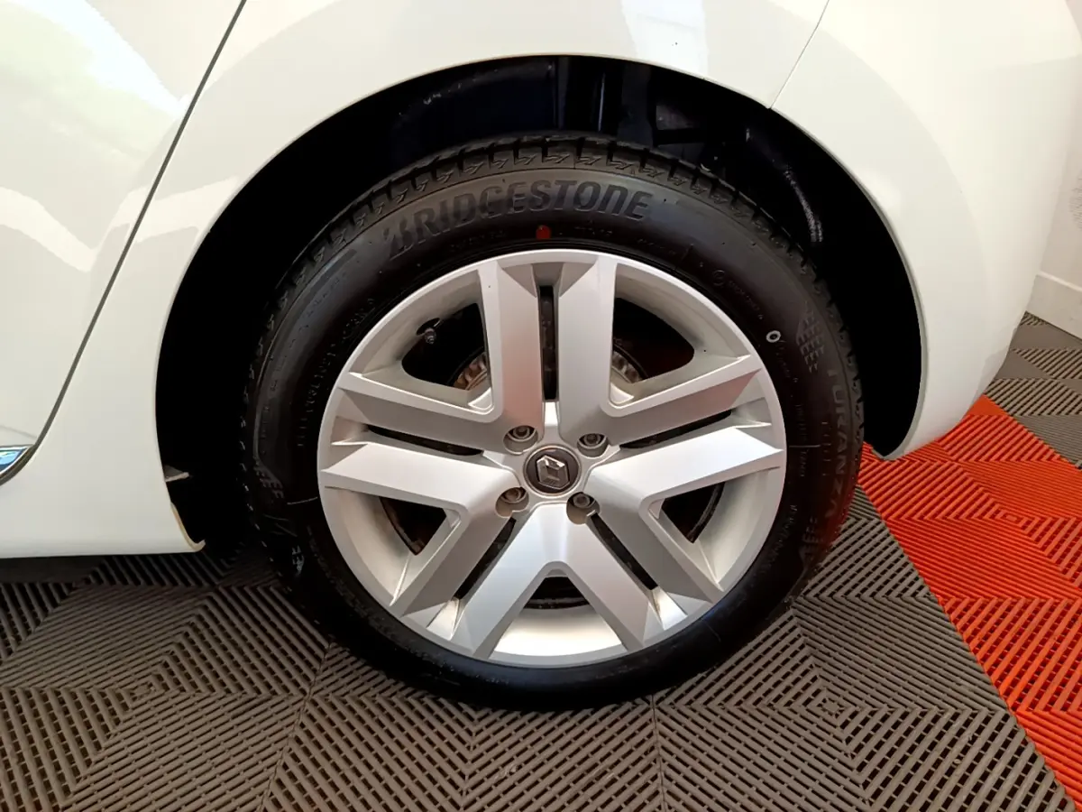 Gros plan sur la roue arrière droite d'une Renault Clio Business blanche, avec partie de la carrosserie visible.