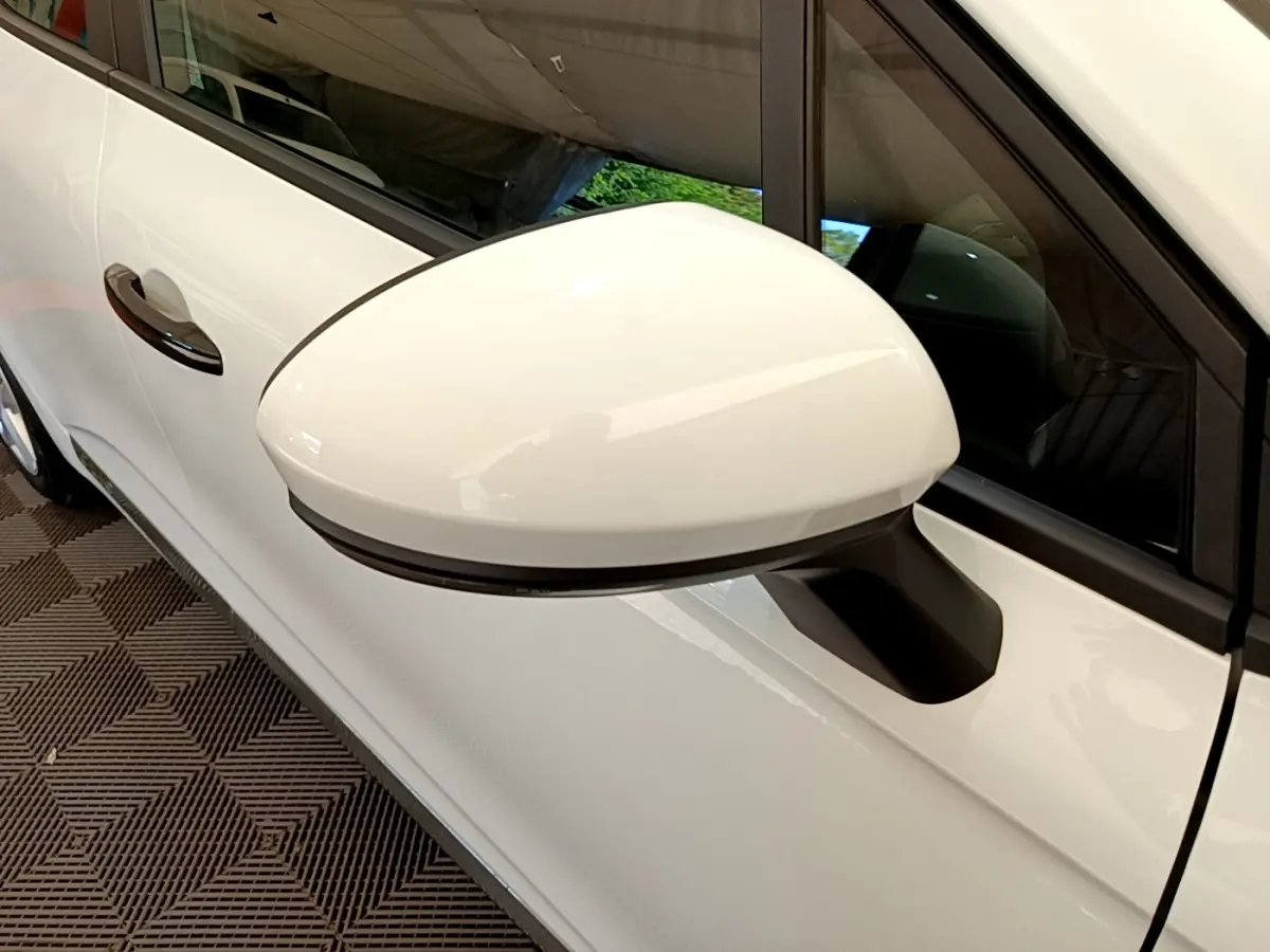 Rétroviseur droit blanc de la Renault Clio Business 2021, avec poignée de porte assortie visible en arrière-plan.