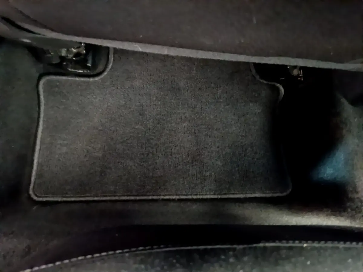 Tapis de sol noir côté conducteur dans une Renault Clio Business blanche vue de l'intérieur au sol.