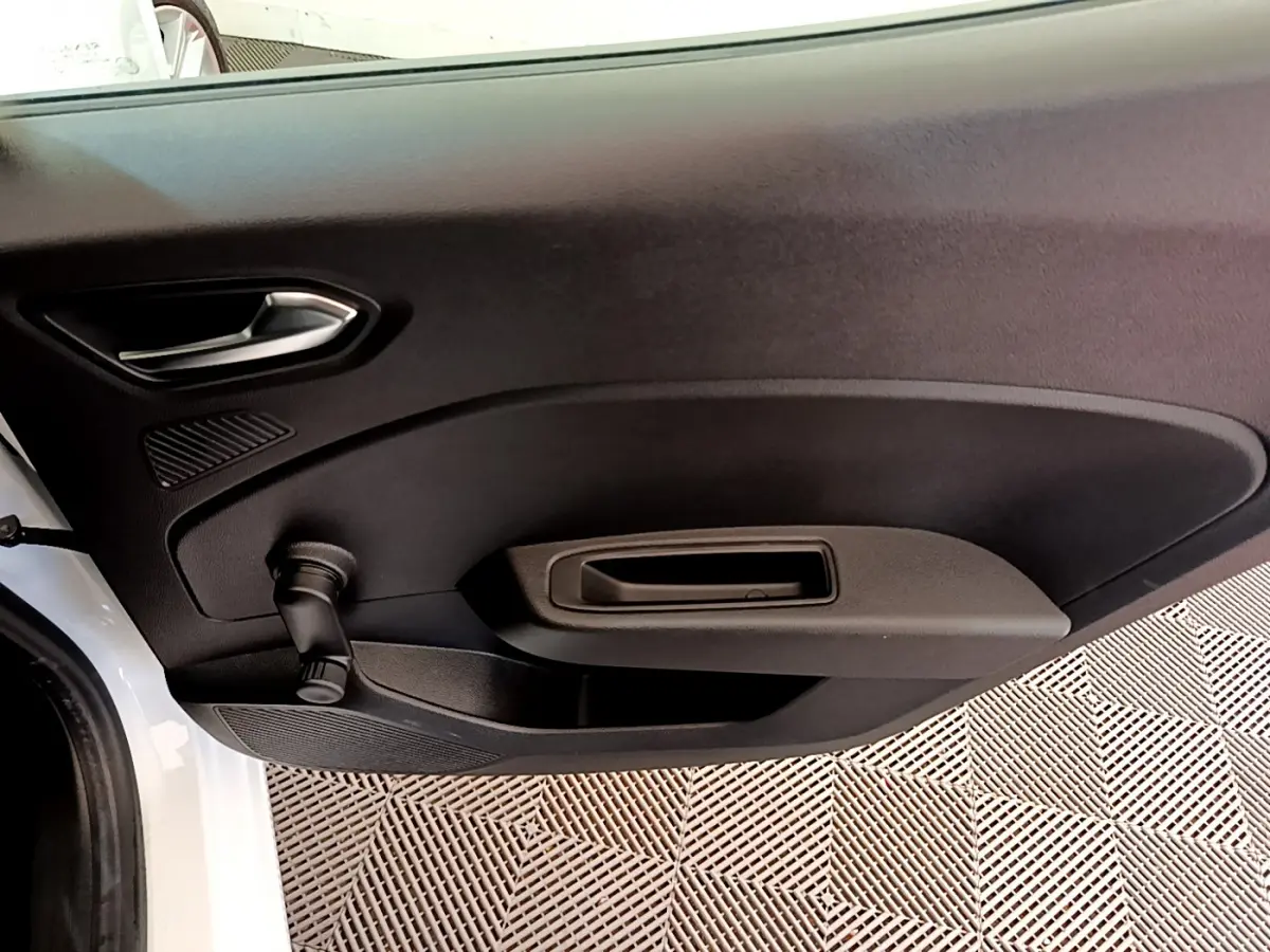 Vue rapprochée de la porte avant gauche noire d'une Renault Clio Business blanche avec poignée et manivelle de vitre.