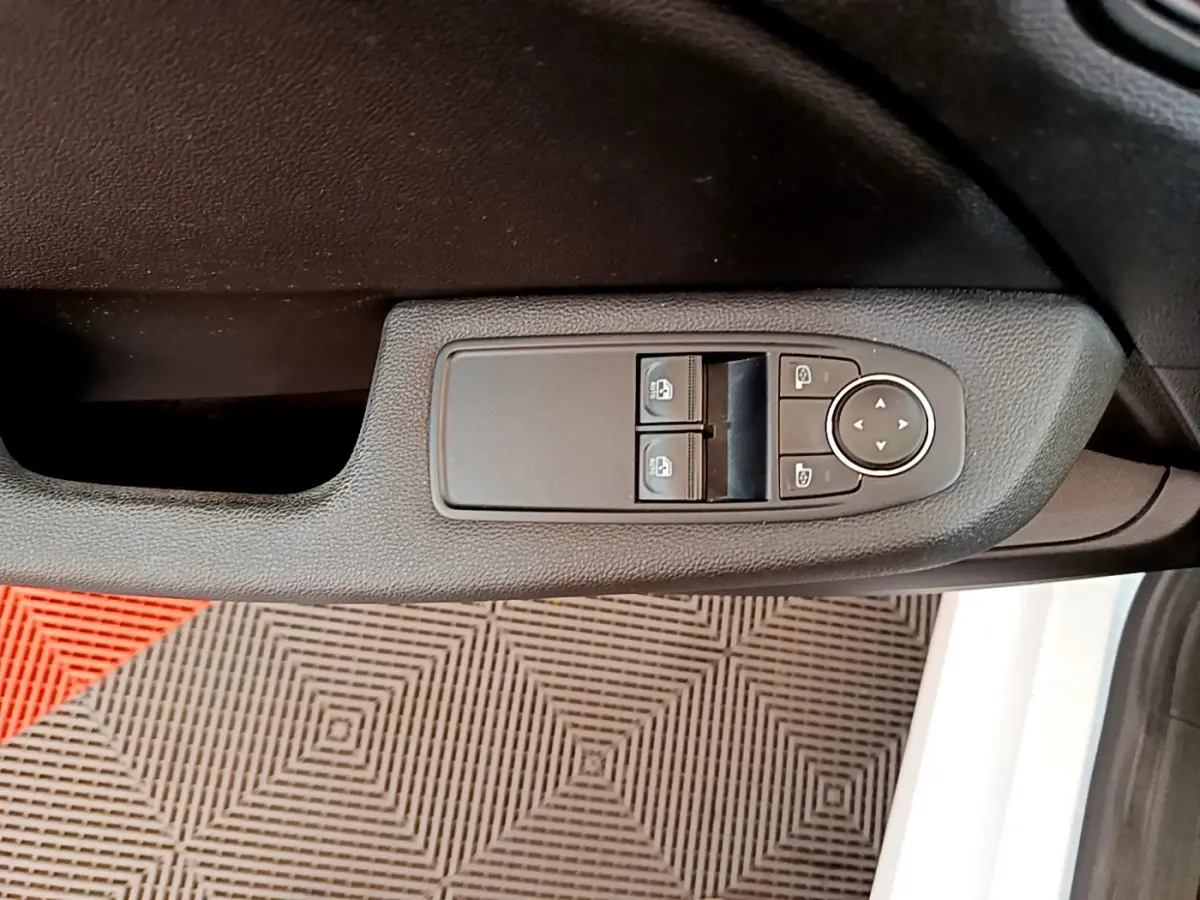 Panneau de commandes des vitres et rétroviseurs côté conducteur de la Renault Clio Business blanche, vue intérieure rapprochée.