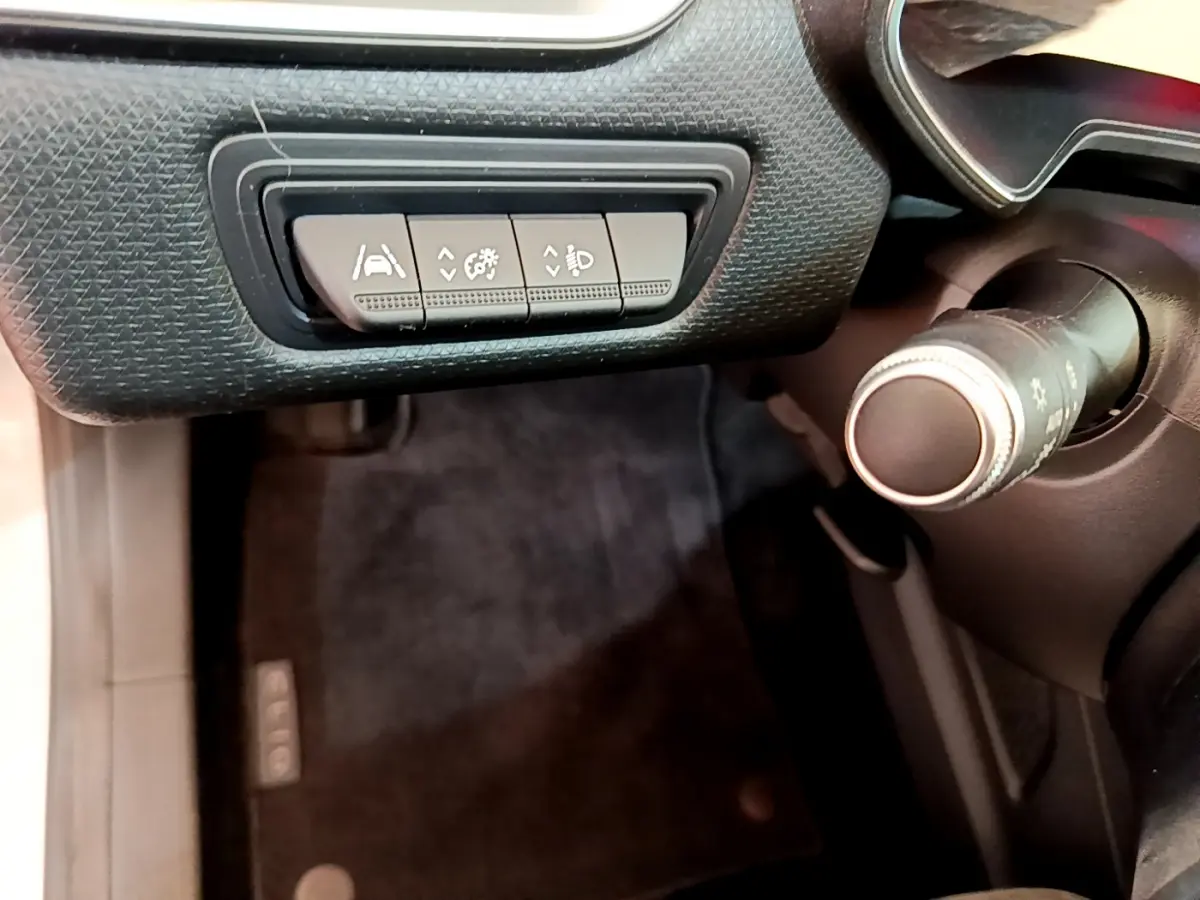 Détail des commandes d'assistance au conducteur sur le tableau de bord côté gauche d'une Renault Clio Business blanche 2021.