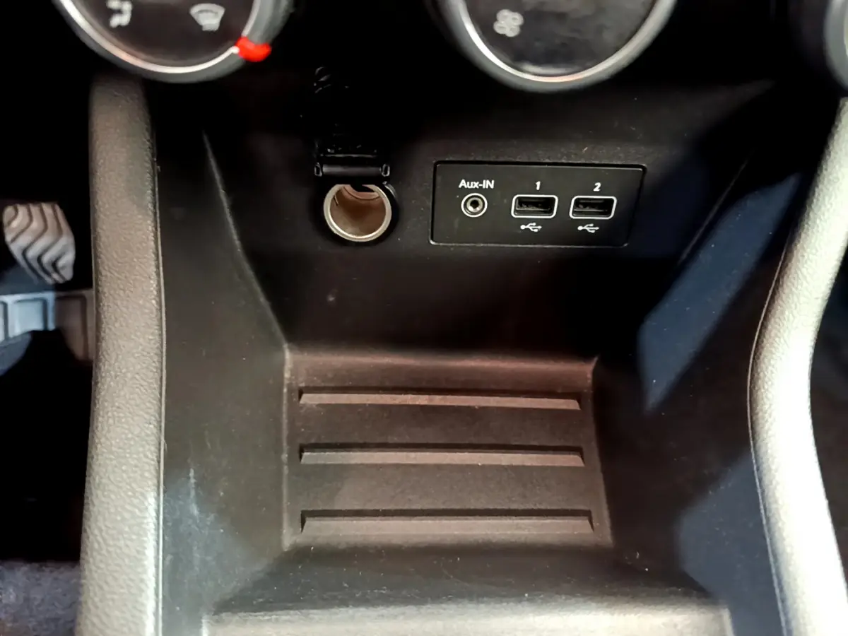 Vue rapprochée de la console centrale noire de la Renault Clio Business SCe 65 avec prises USB et prise auxiliaire.