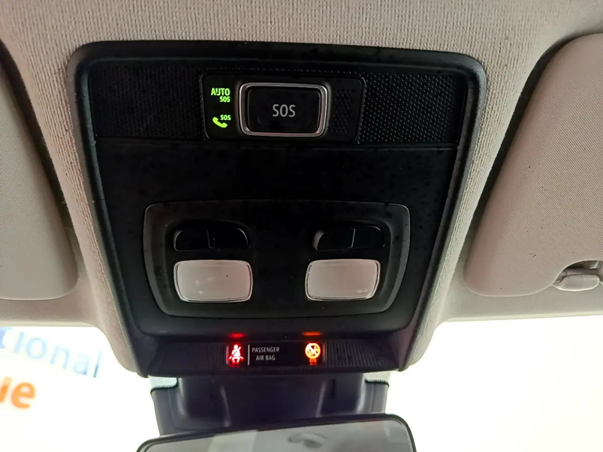 Vue en contre-plongée du plafonnier intérieur de la Renault Clio Business blanc avec bouton SOS et voyants allumés.
