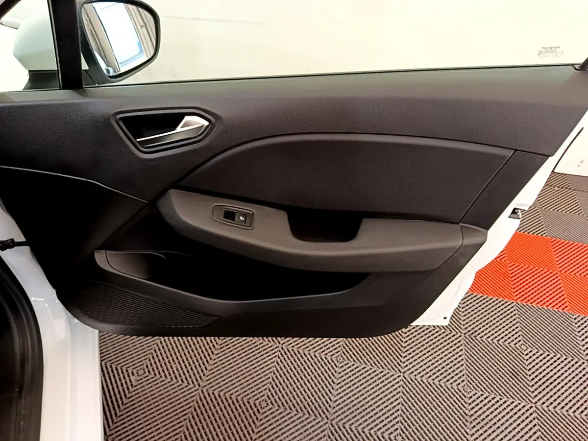 Vue côté gauche de la porte intérieure noire d'une Renault Clio Business blanche, avec poignée et commande de vitre.