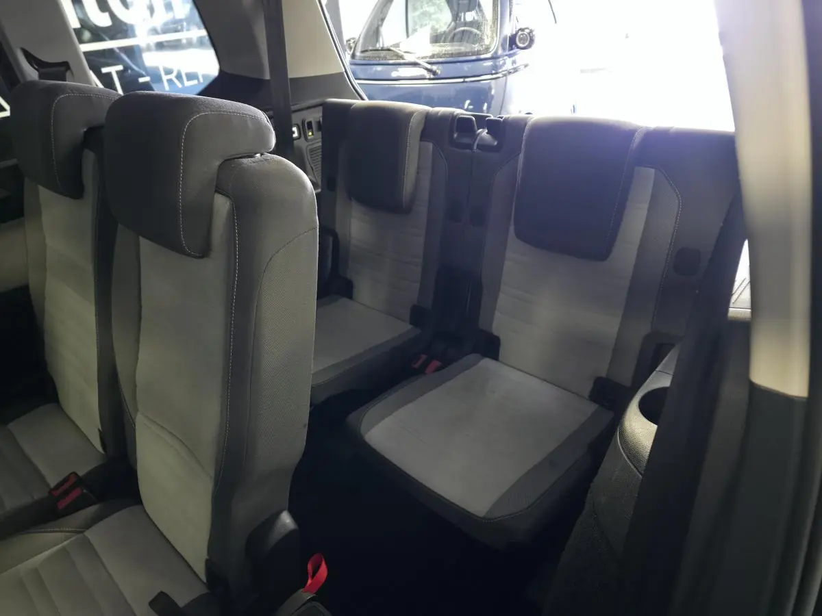 Vue intérieure sur les sièges arrière gris du Volkswagen Touran 2024, montrant la troisième rangée et les appuie-têtes.