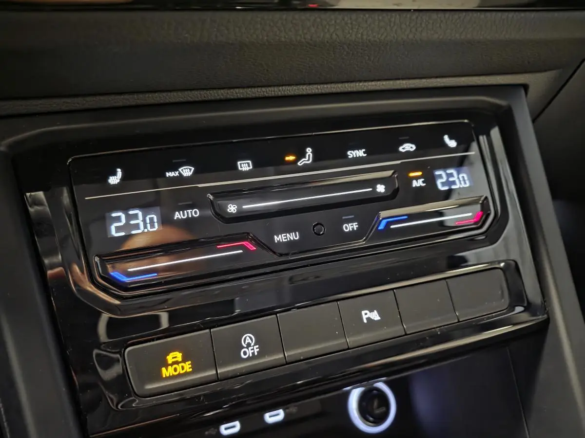 Détail du tableau de bord du Volkswagen Touran 2024 montrant la climatisation automatique à 23°C et commandes tactiles.