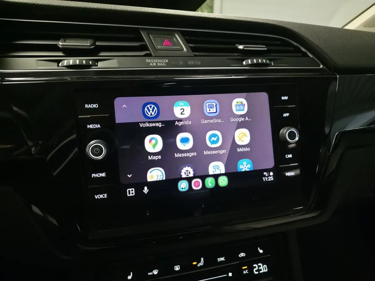 Écran tactile central du tableau de bord du Volkswagen Touran 2024, affichant des applications connectées.