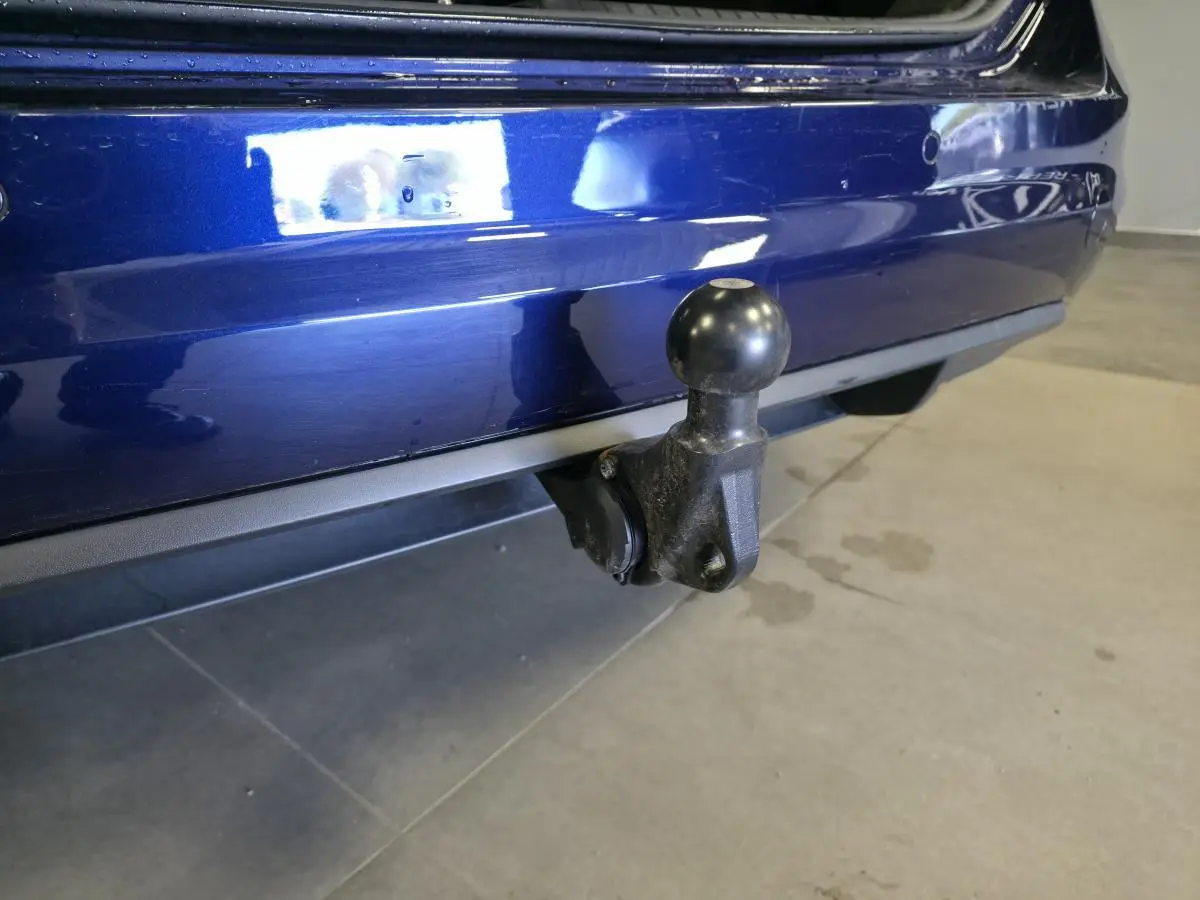 Gros plan sur le crochet d'attelage escamotable arrière d'un Volkswagen Touran bleu 2024.