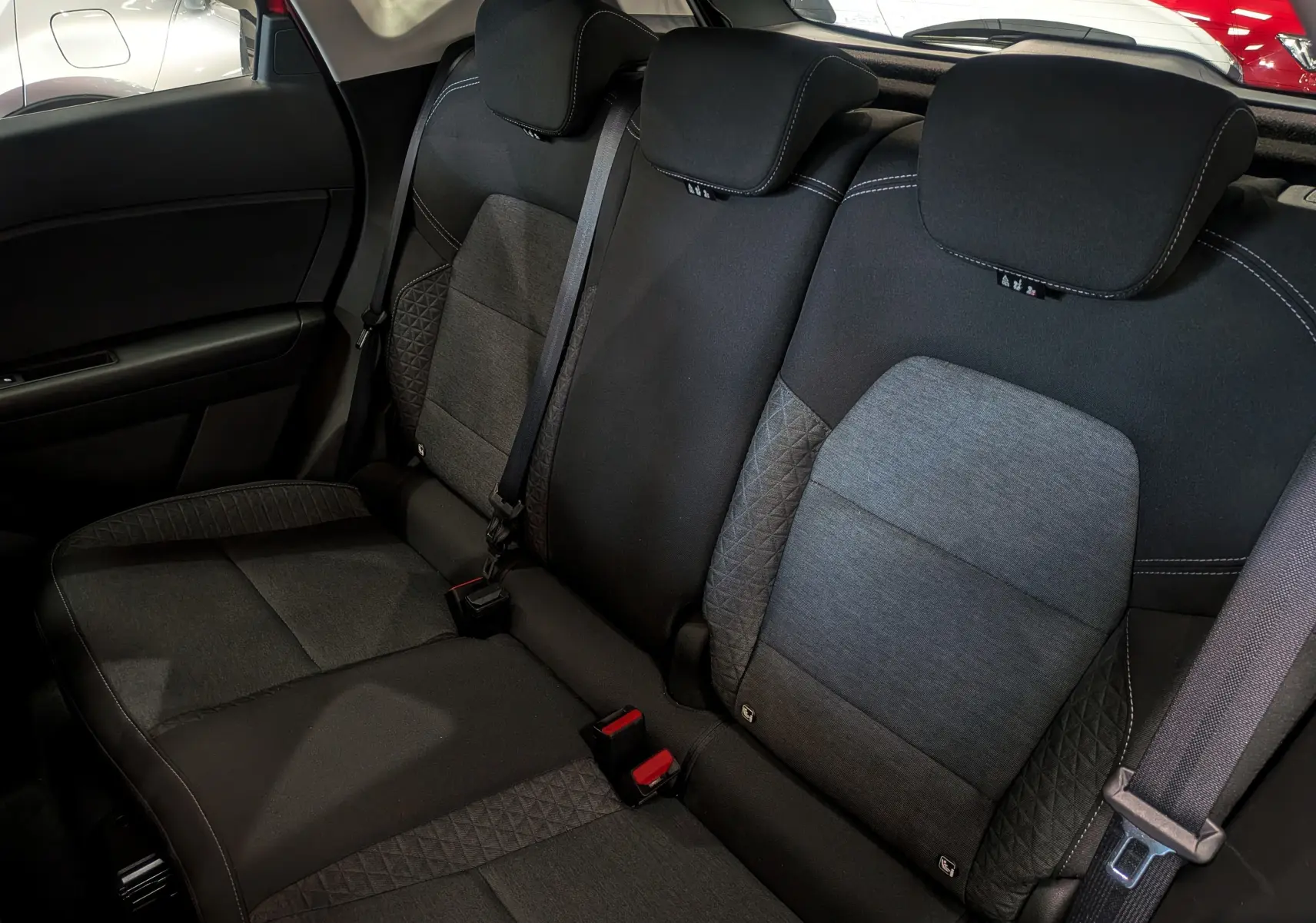 Vue rapprochée des sièges arrière en tissu gris et noir du Renault Captur TCe 90 CH Zen 2023.