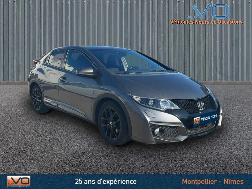 Vue 3/4 avant gauche d'une Honda Civic gris métallisé 2015 avec jantes alliage noires et vitres surteintées.
